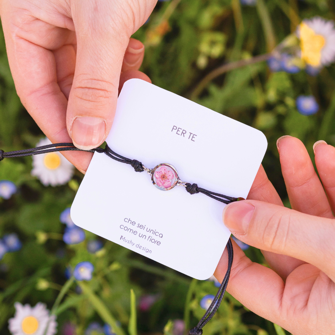 Bracciale regolabile in cordoncino e ciondolo in acciaio inox con fiore selvatico rosa