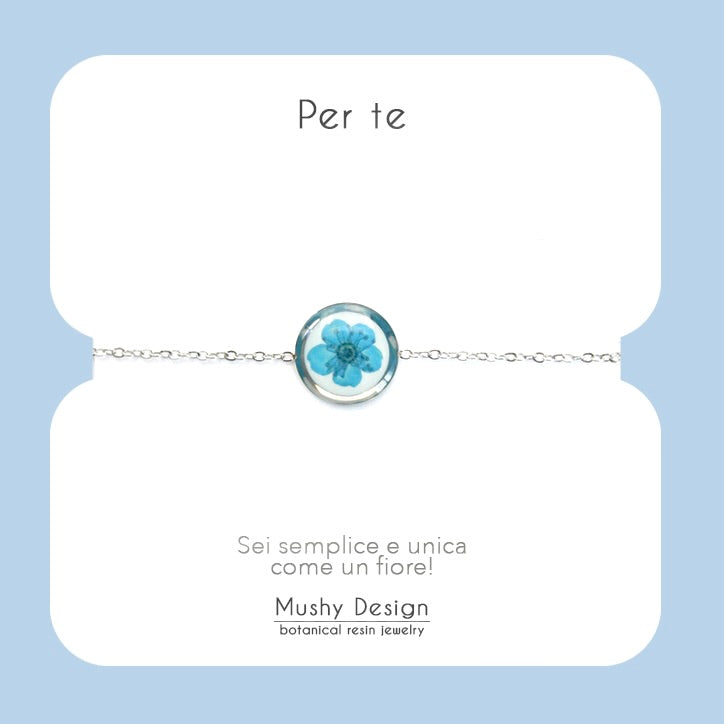 Bracciale in acciaio inossidabile con ciondolo in resina e fiore selvatico blu con sfondo bianco
