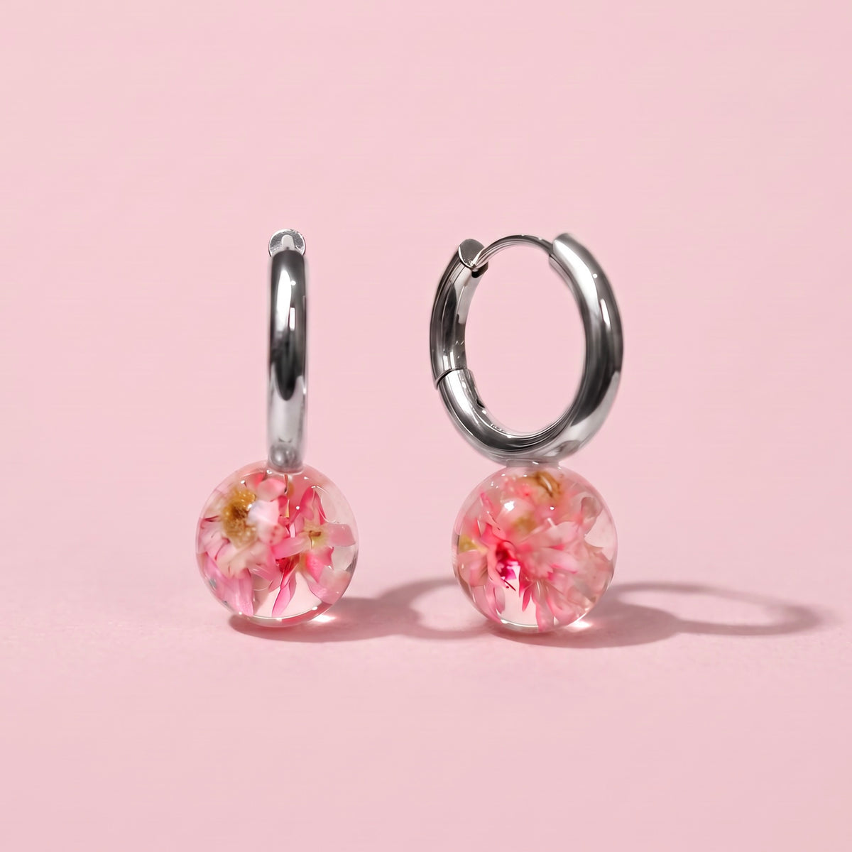 Orecchini a cerchio in acciaio inox con fiore Glixia rosa preservata nella resina