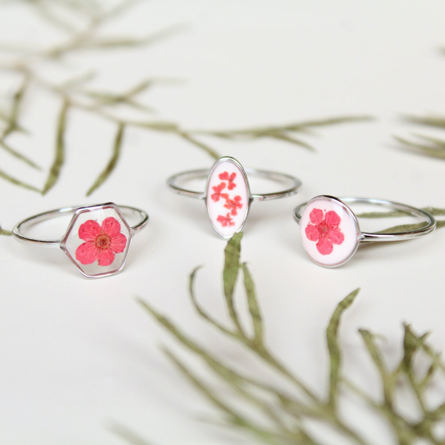 Anello in acciaio inox e fiore selvatico rosso intersecato nella resina