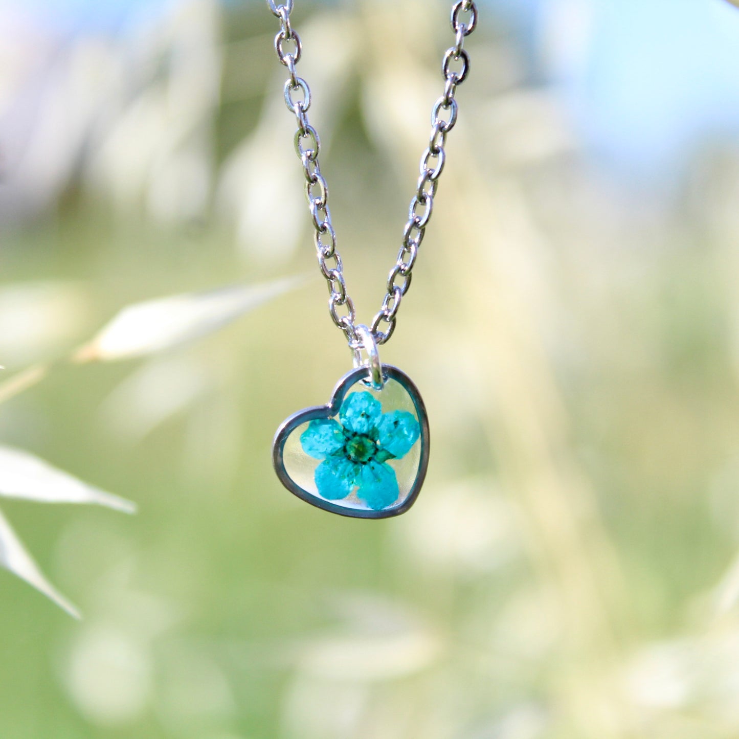 Collana cuore in acciaio inossidabile e ciondolo in resina con fiore selvatico blu