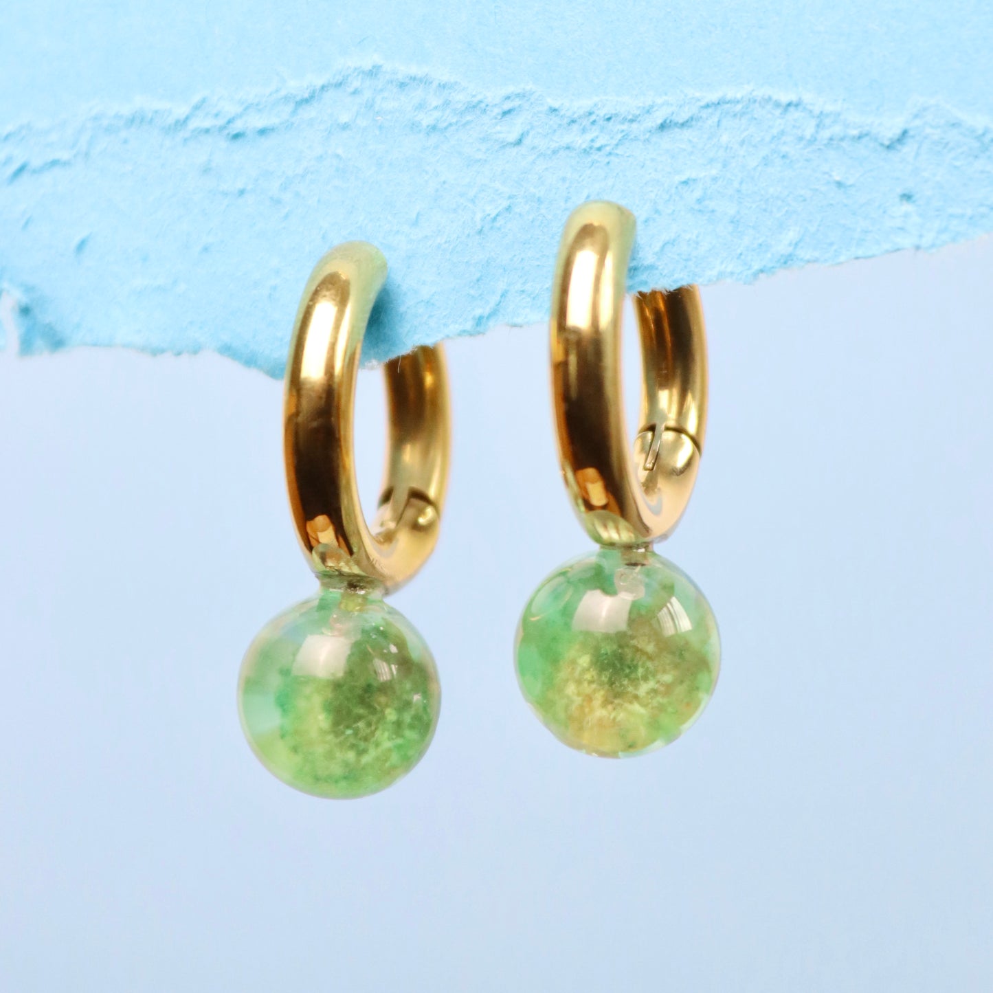 Orecchini a cerchio in acciaio inox oro con fiore Glixia verde intersecata nella resina