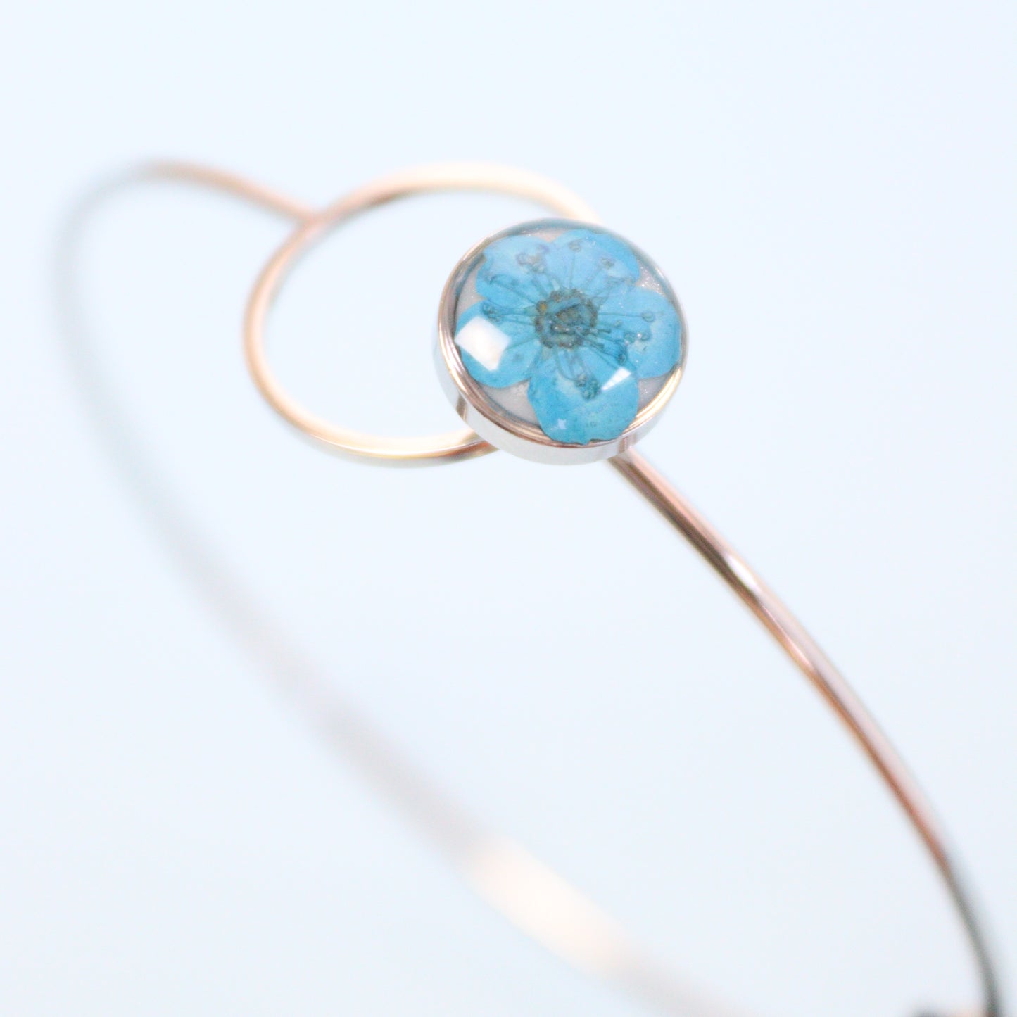 Bracciale ABBRACCIAMI in acciaio inox con resina e fiore selvatico blu