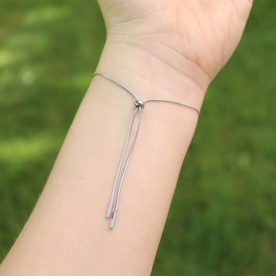 Bracciale scorrevole in acciaio inox e fiore fucsia preservato nel ciondolo