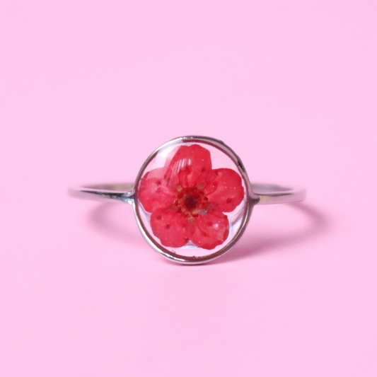 Anello in acciaio inox e fiore selvatico rosso intersecato nella resina