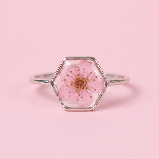Anello in acciaio inox e fiore selvatico rosa intersecato nella resina