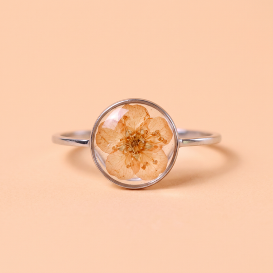 Anello in acciaio inox e fiore vero arancio intersecato nella resina