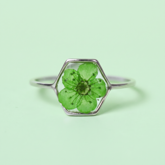 Anello in acciaio inox e fiore selvatico verde intersecato nella resina