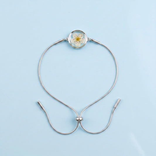 Bracciale scorrevole in acciaio inox e fiore bianco preservato nel ciondolo