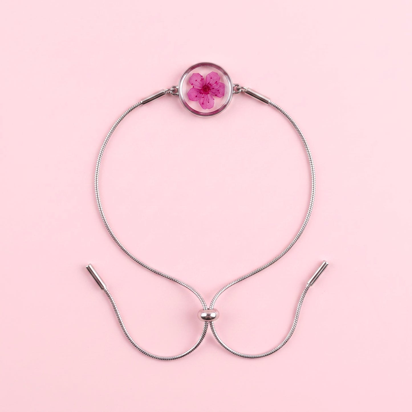 Bracciale scorrevole in acciaio inox e fiore fucsia preservato nel ciondolo