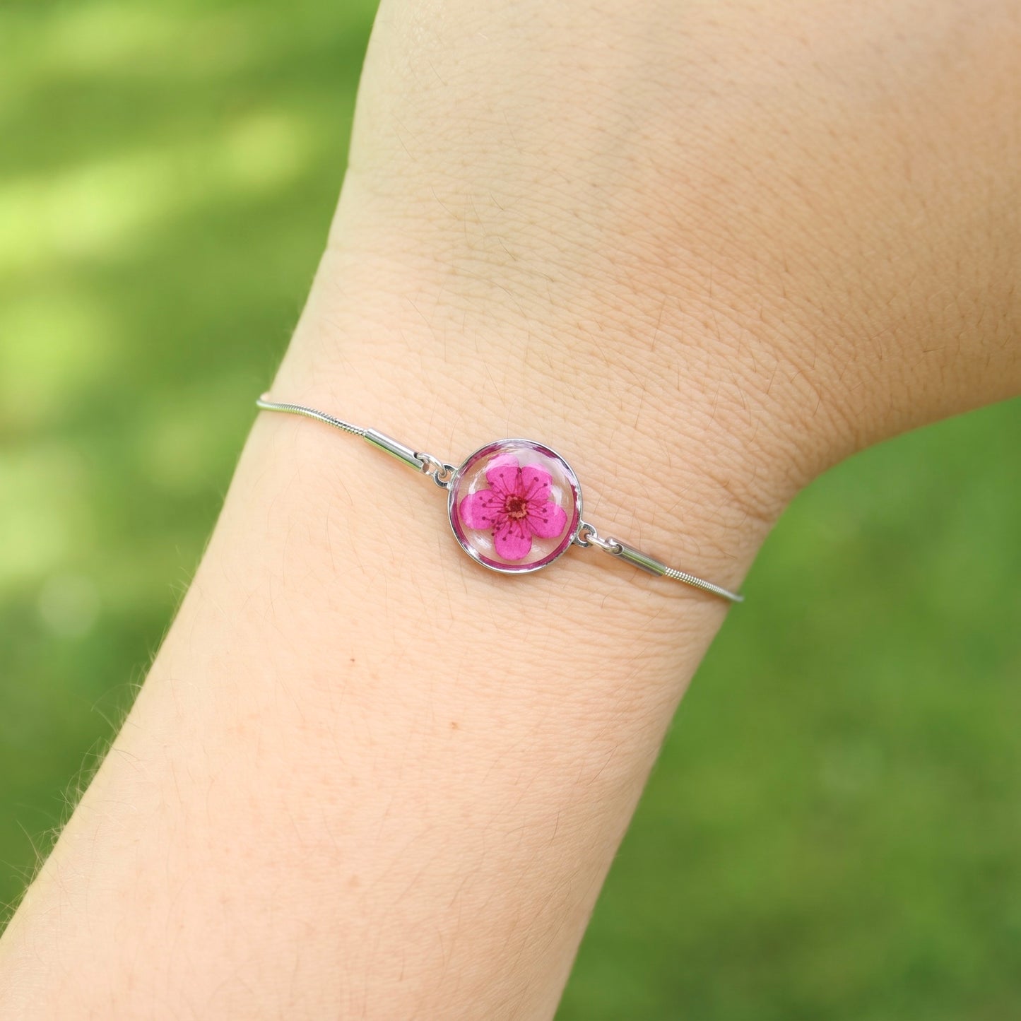 Bracciale scorrevole in acciaio inox e fiore fucsia preservato nel ciondolo