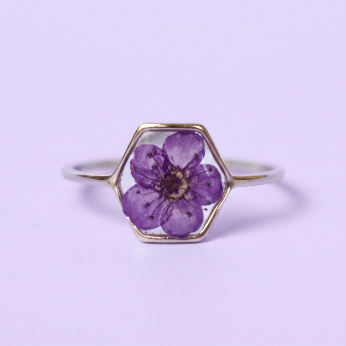 Anello in acciaio inox e fiore selvatico verde intersecato nella resina viola