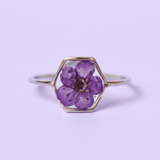 Anello in acciaio inox e fiore selvatico verde intersecato nella resina viola
