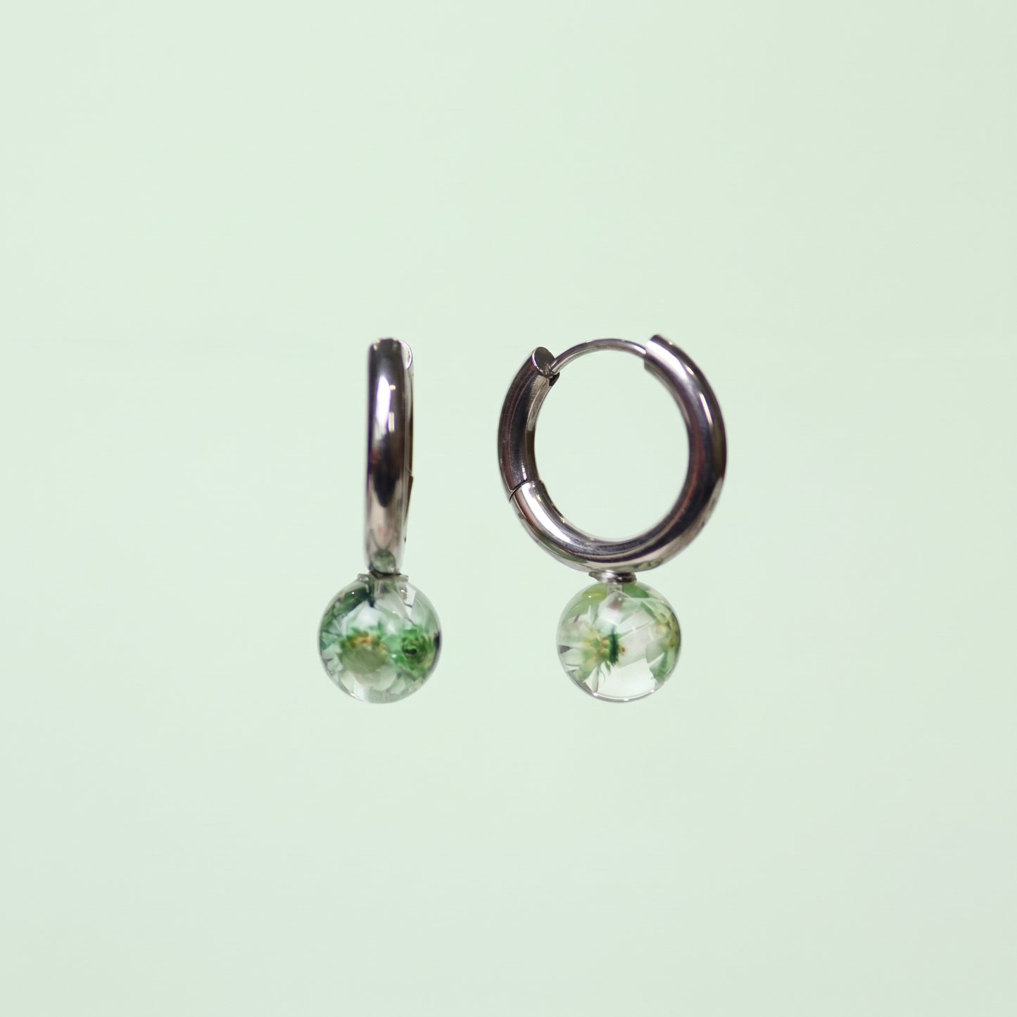 Orecchini a cerchio in acciaio inox con fiore Glixia verde preservato nella resina