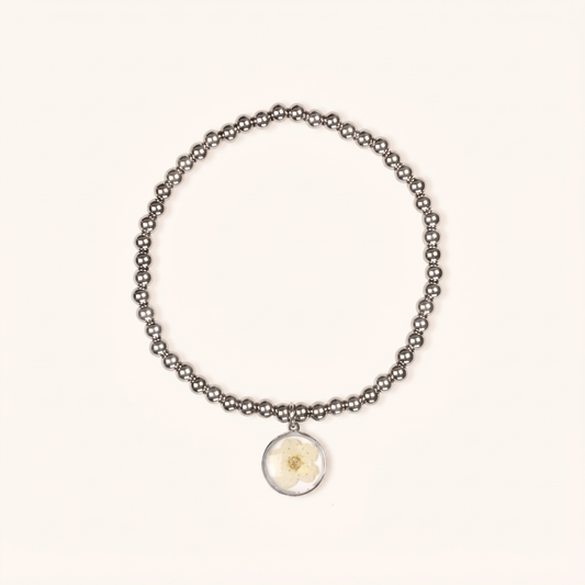 Bracciale elastico in acciaio inossidabile e ciondolo in resina con fiore selvatico bianco