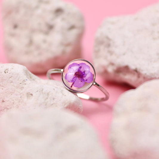 Anello in acciaio inox e fiore vero viola intersecato nella resina