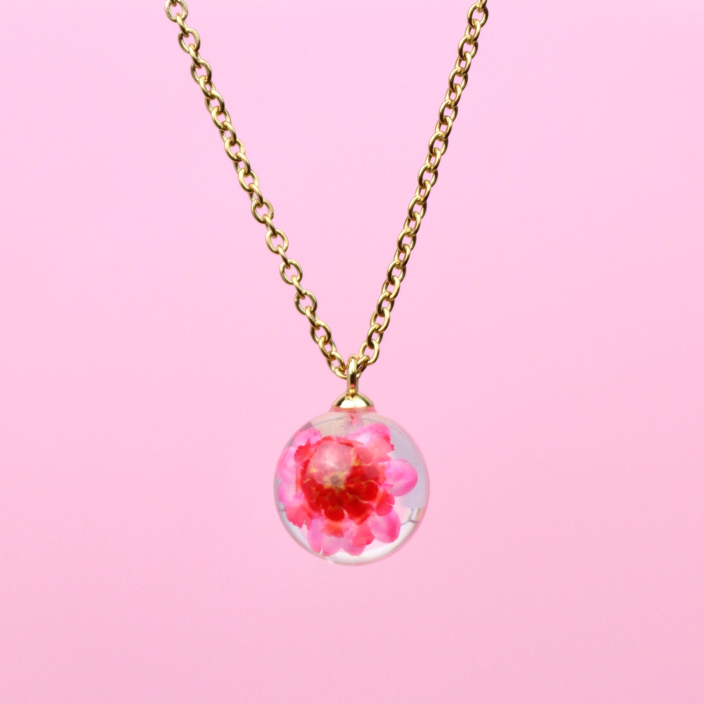 Collana sfera in resina con Glixia rosa e montatura in acciaio inox, collezione ATTRAVERSO