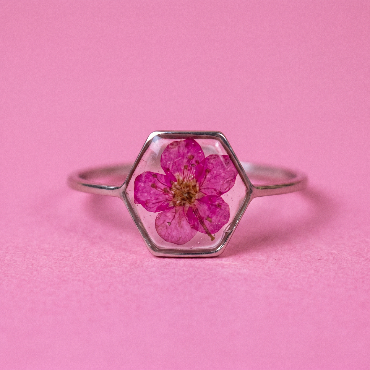 Anello in acciaio inox e fiore selvatico fucsia intersecato nella resina
